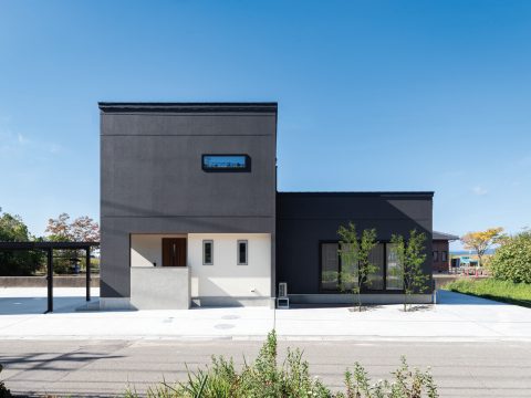 黒い外壁と大きな軒が迎える三世帯の家
